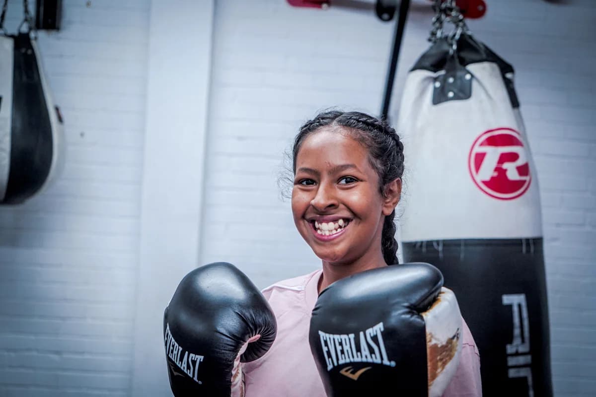 A participant smiling while wearing boxing gloves